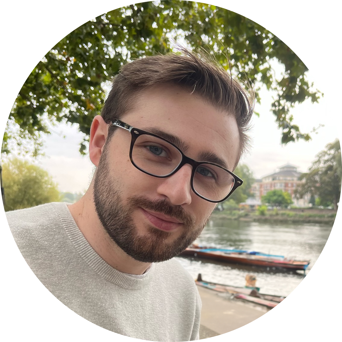 A picture of me by a river and some boats.